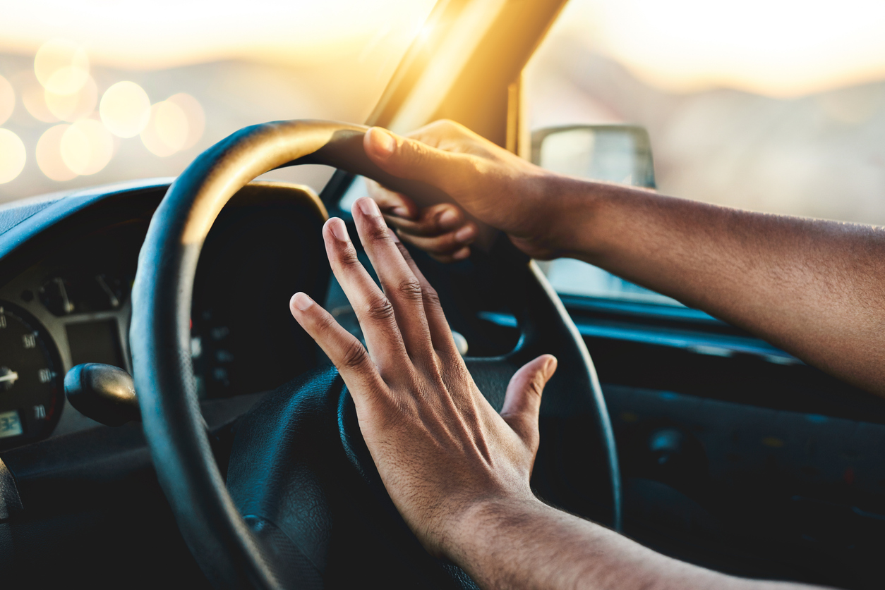 Man honking his car horn in a road rage.